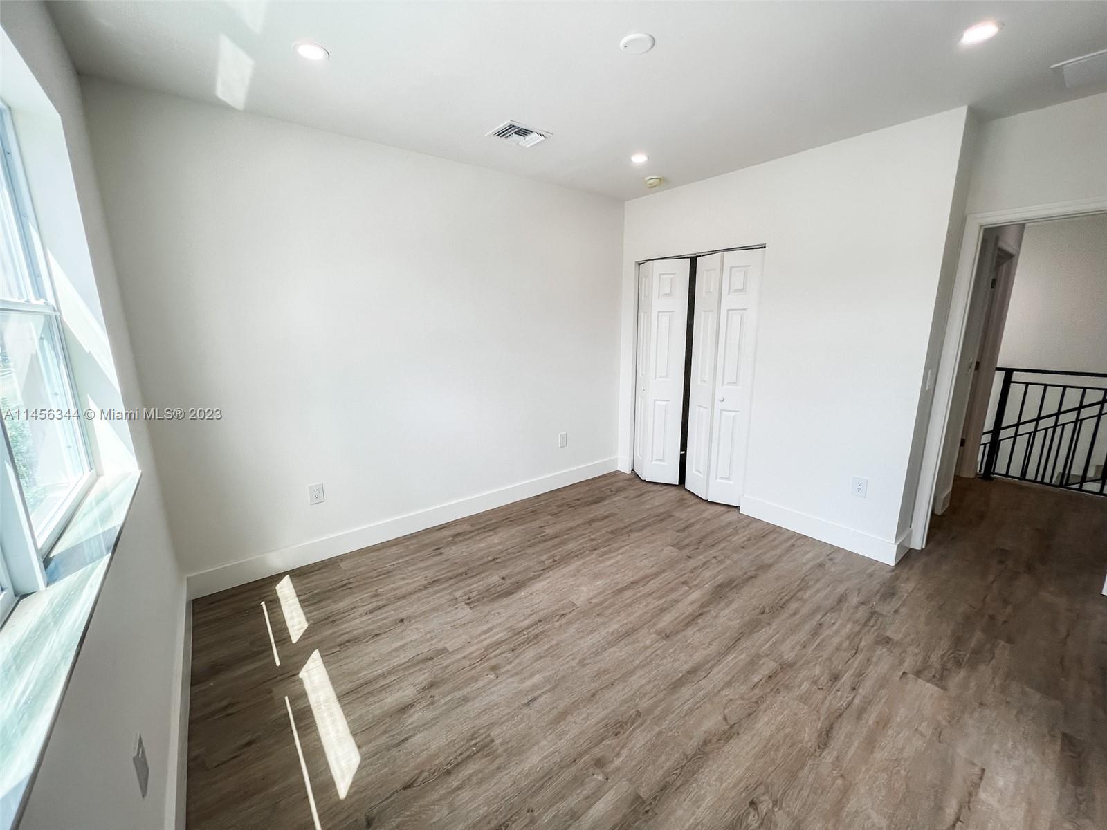 Collier City Pompano Beach, FL 33069 - Photo 17 of 28 an empty room with wooden floor and entrance