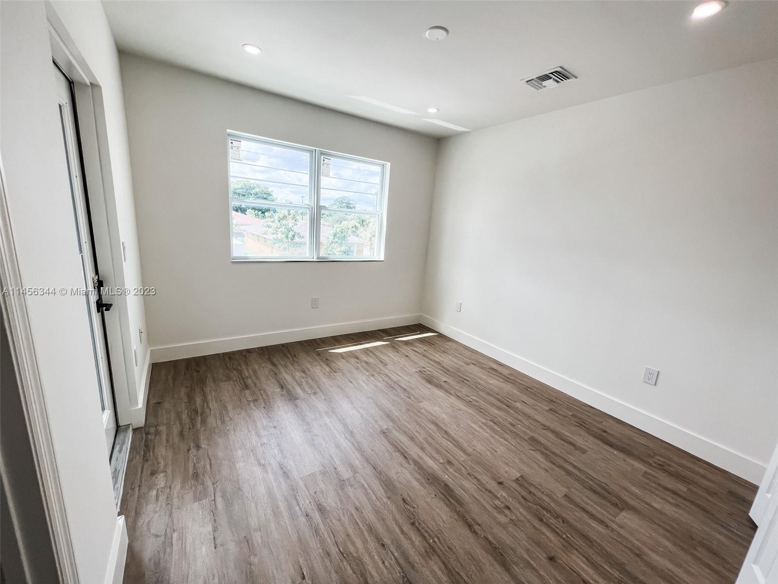 Collier City Pompano Beach, FL 33069 - Photo 18 of 28 an empty room with wooden floor and windows
