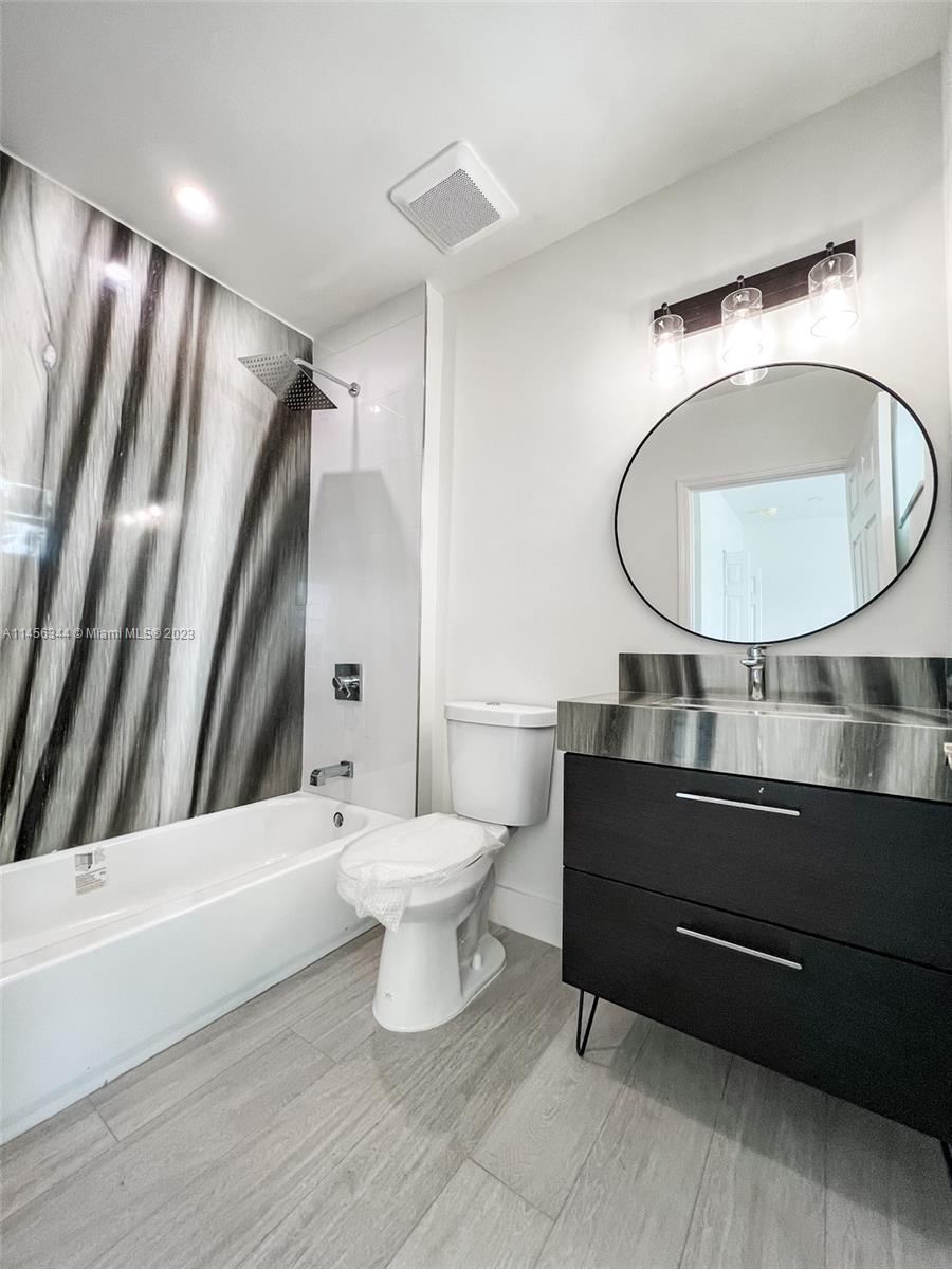 Collier City Pompano Beach, FL 33069 - Photo 19 of 28 a bathroom with a sink a toilet and a mirror