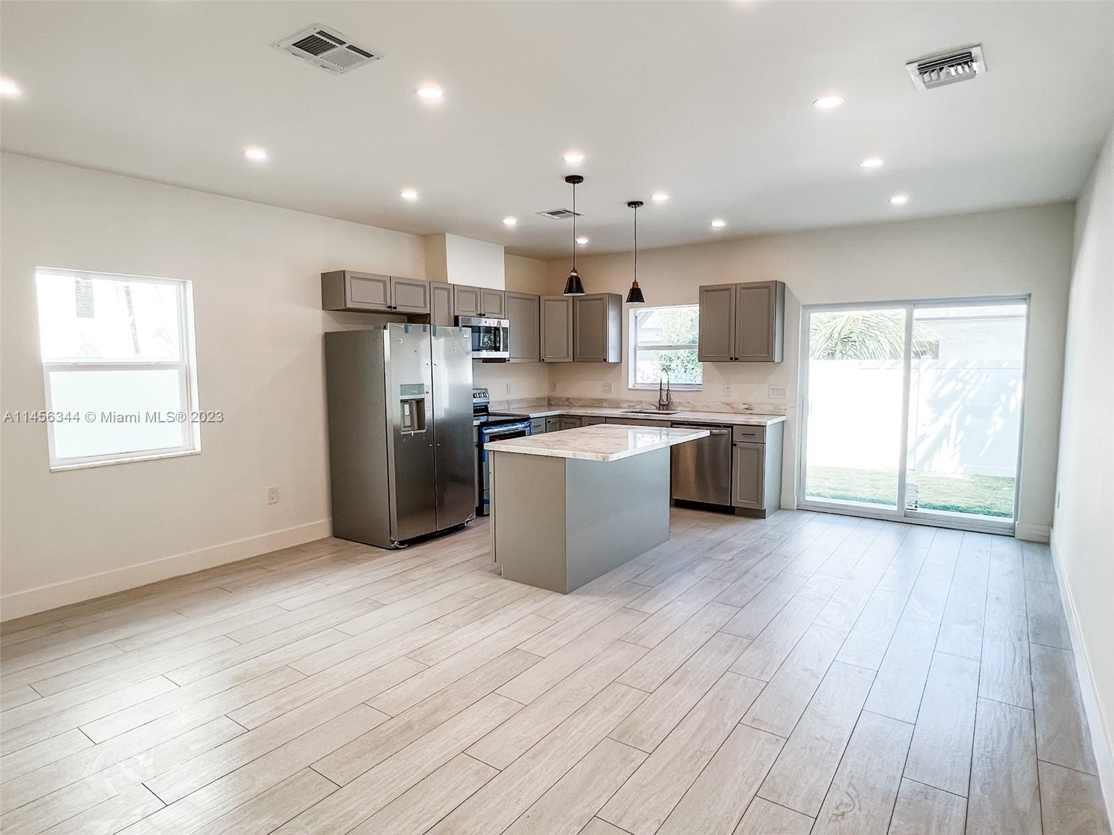 Collier City Pompano Beach, FL 33069 - Photo 24 of 28 a large kitchen with stainless steel appliances granite countertop a stove and a refrigerator