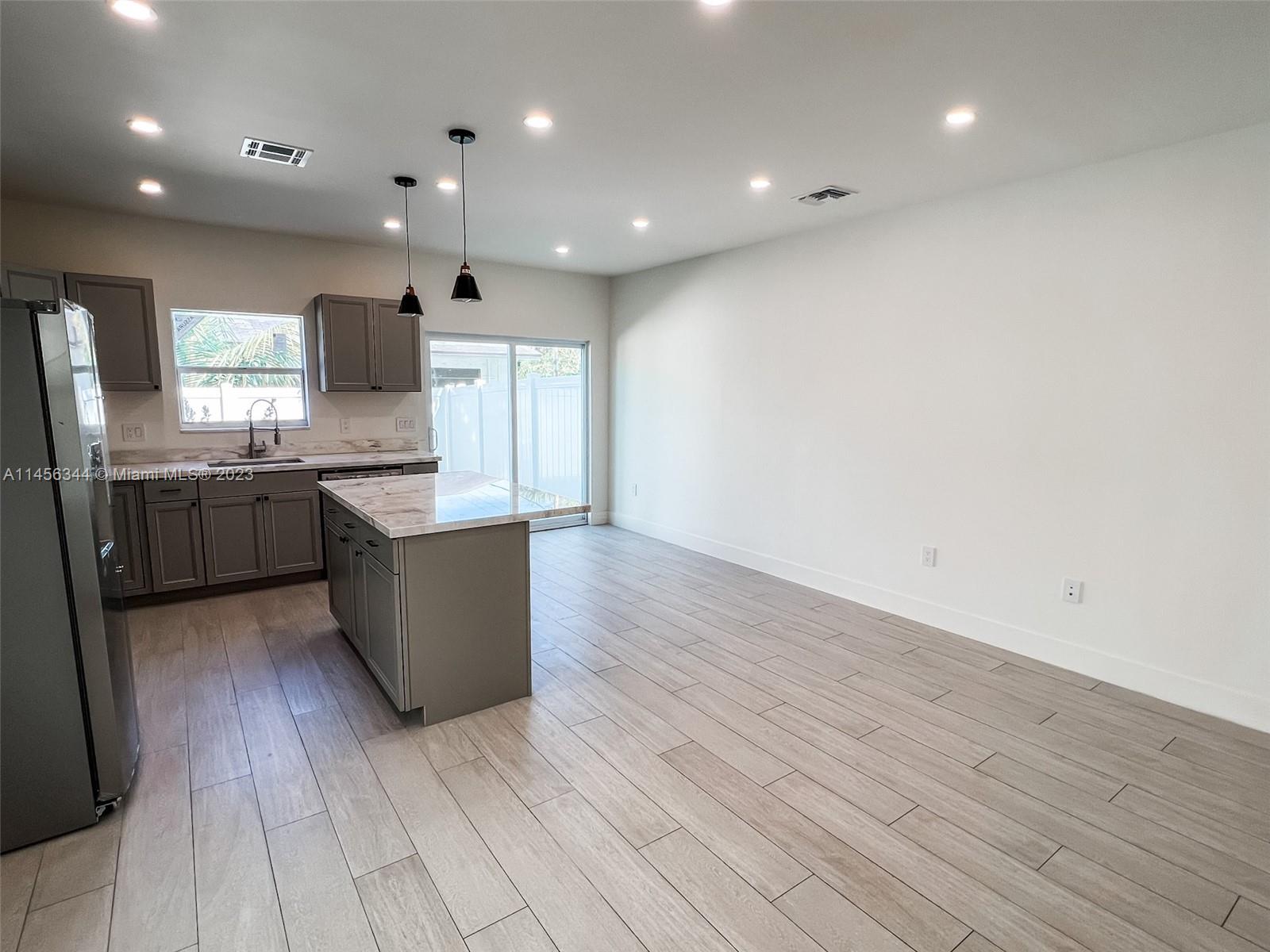 Collier City Pompano Beach, FL 33069 - Photo 25 of 28 a large kitchen with stainless steel appliances granite countertop a large counter top a sink and a refrigerator