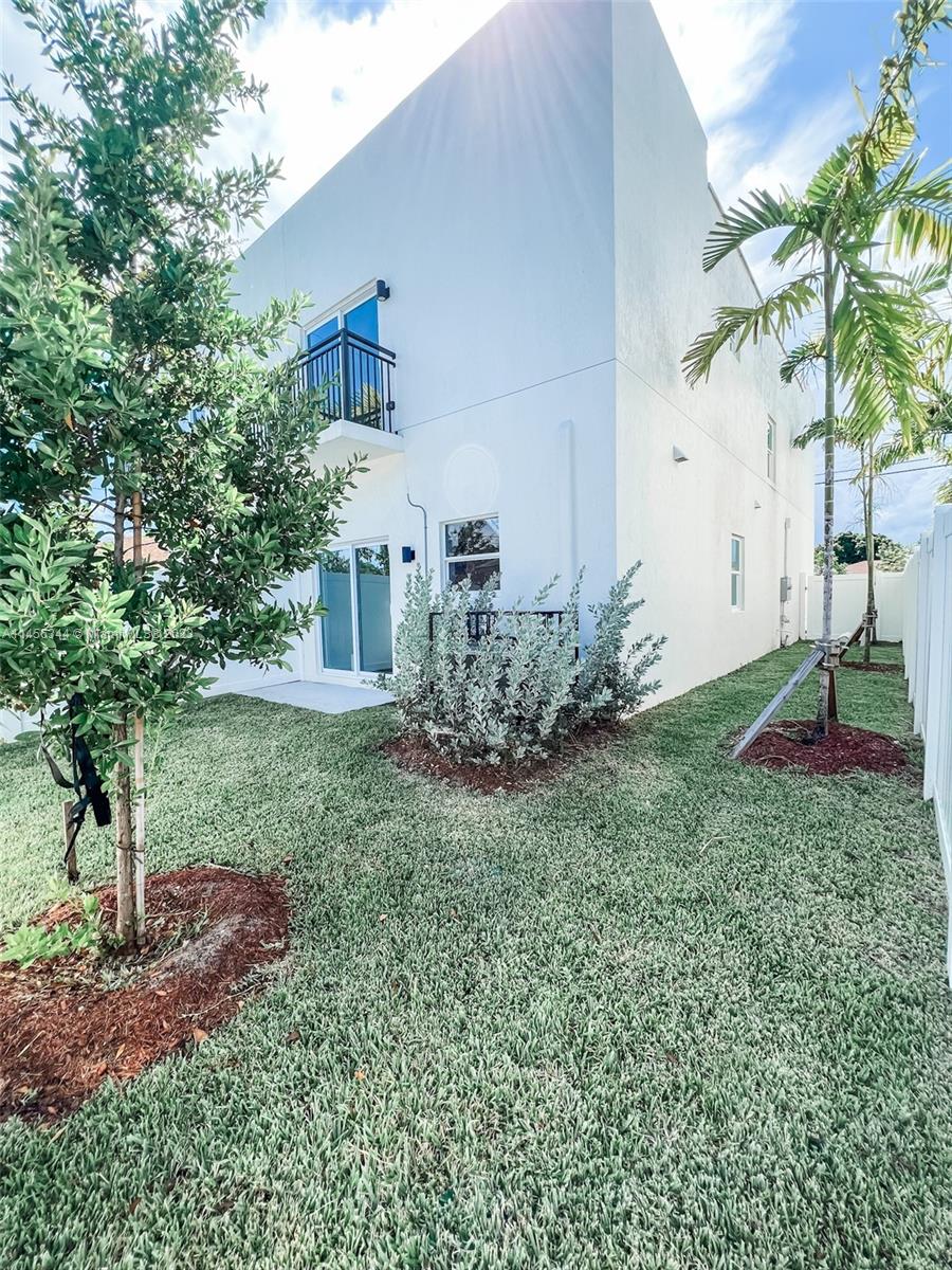 Collier City Pompano Beach, FL 33069 - Photo 27 of 28 a view of a house with a yard and a garden