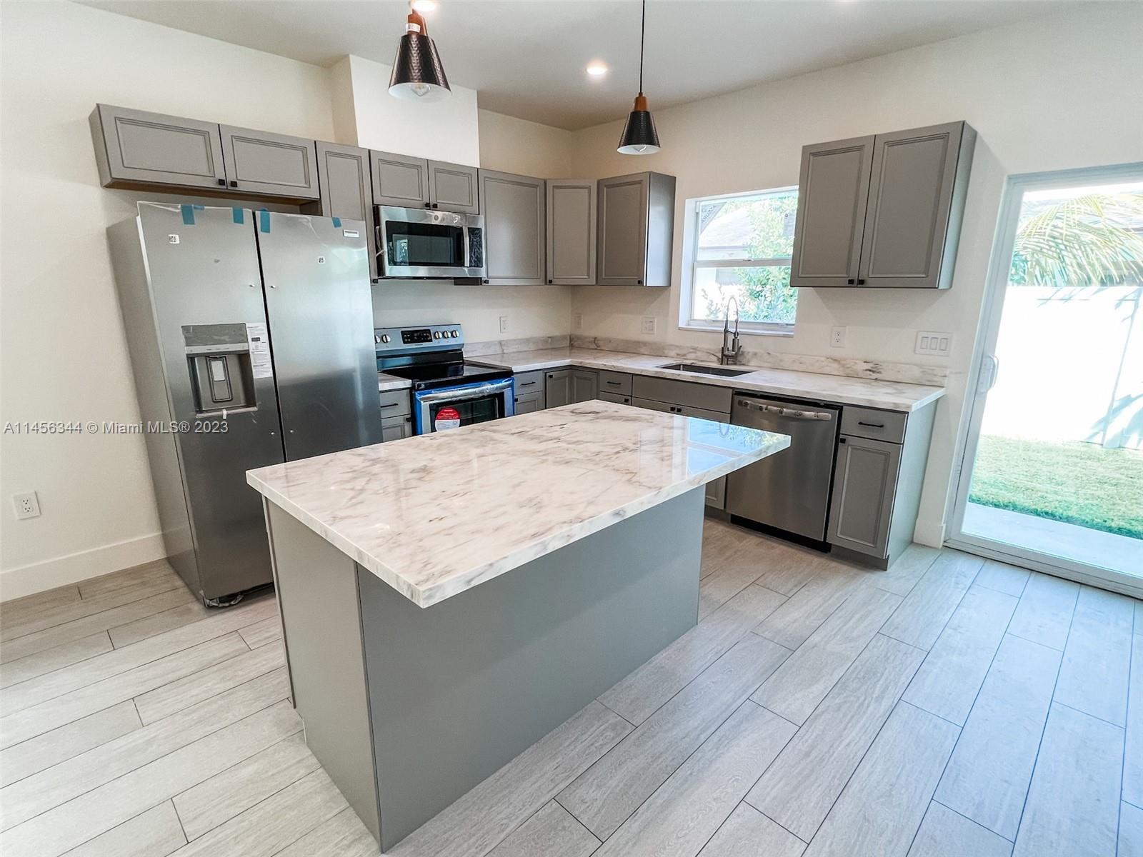 Collier City Pompano Beach, FL 33069 - Photo 6 of 28 a kitchen with stainless steel appliances granite countertop a sink microwave and refrigerator