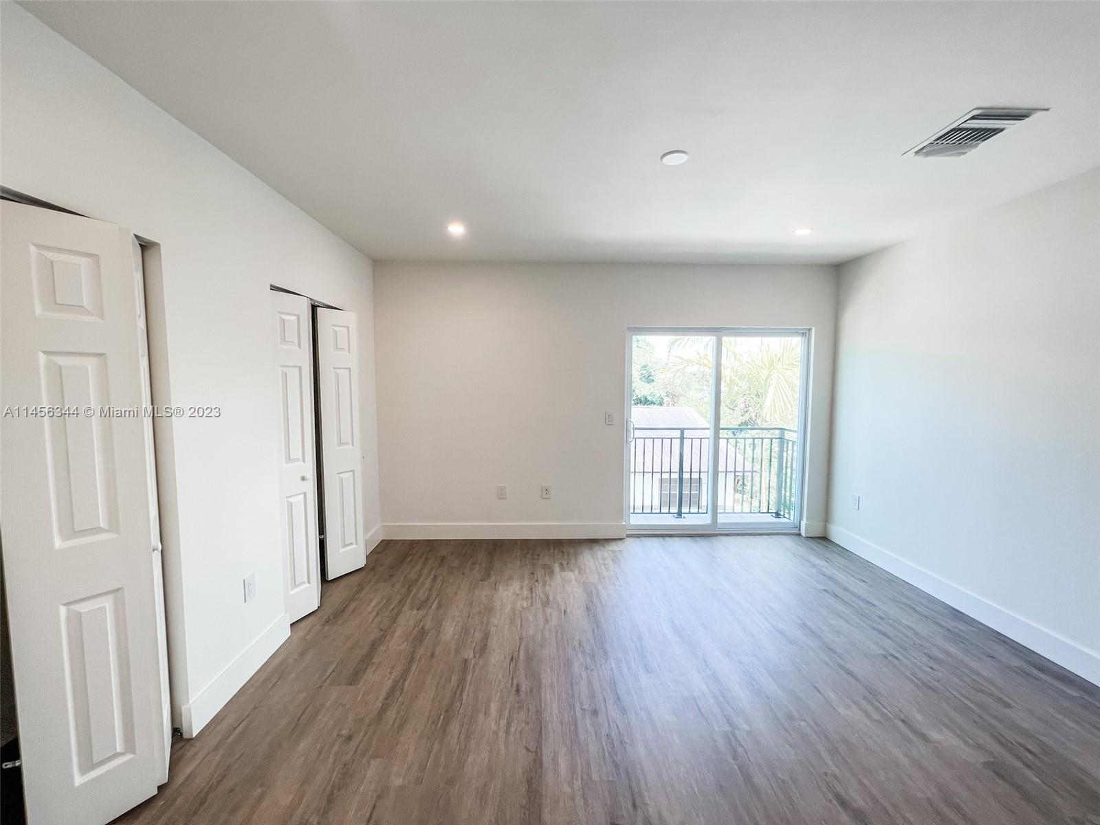Collier City Pompano Beach, FL 33069 - Photo 7 of 28 wooden floor in an empty room with a window