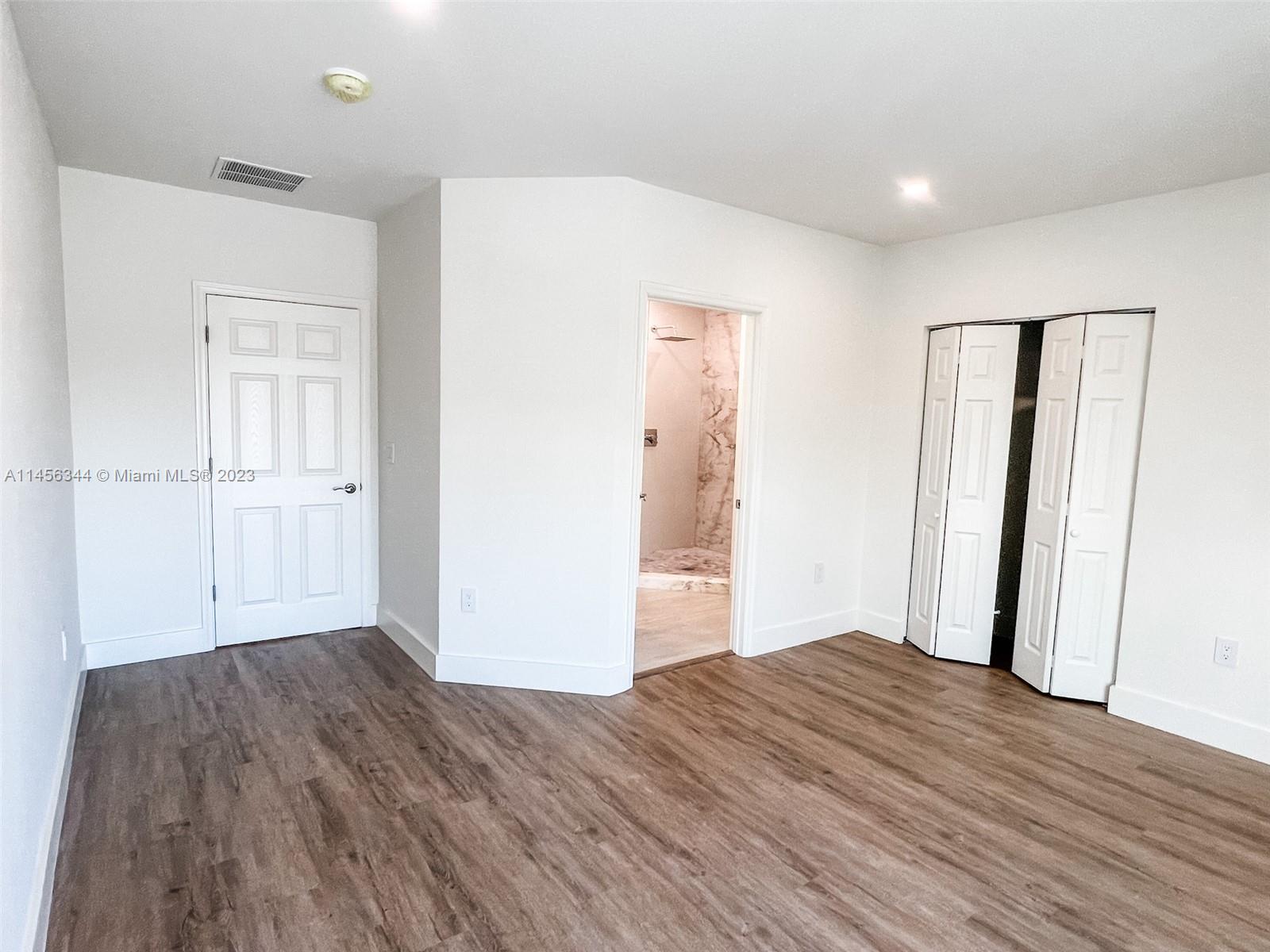 Collier City Pompano Beach, FL 33069 - Photo 8 of 28 wooden floor in an empty room with a window