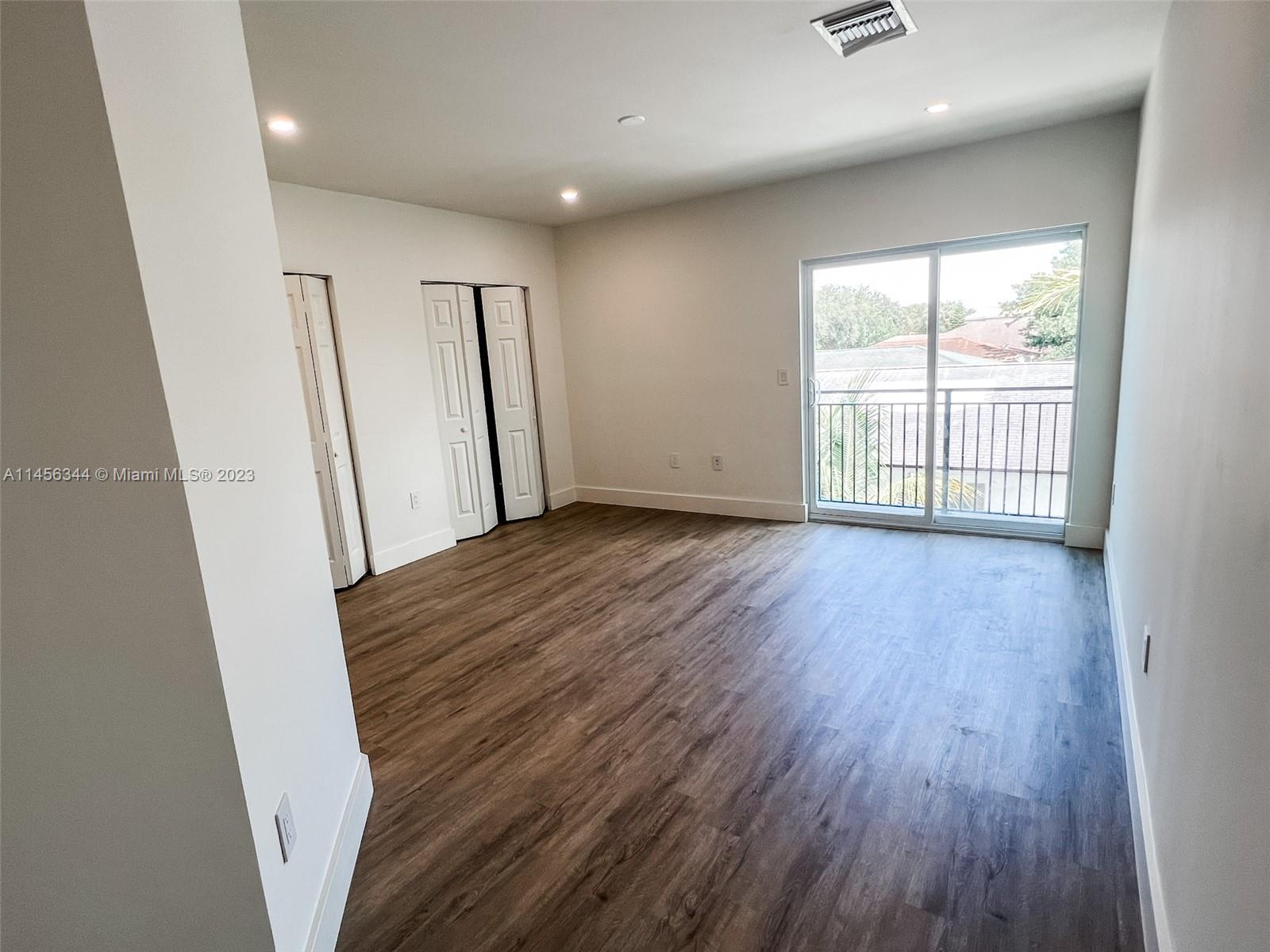 Collier City Pompano Beach, FL 33069 - Photo 9 of 28 wooden floor in an empty room with a window