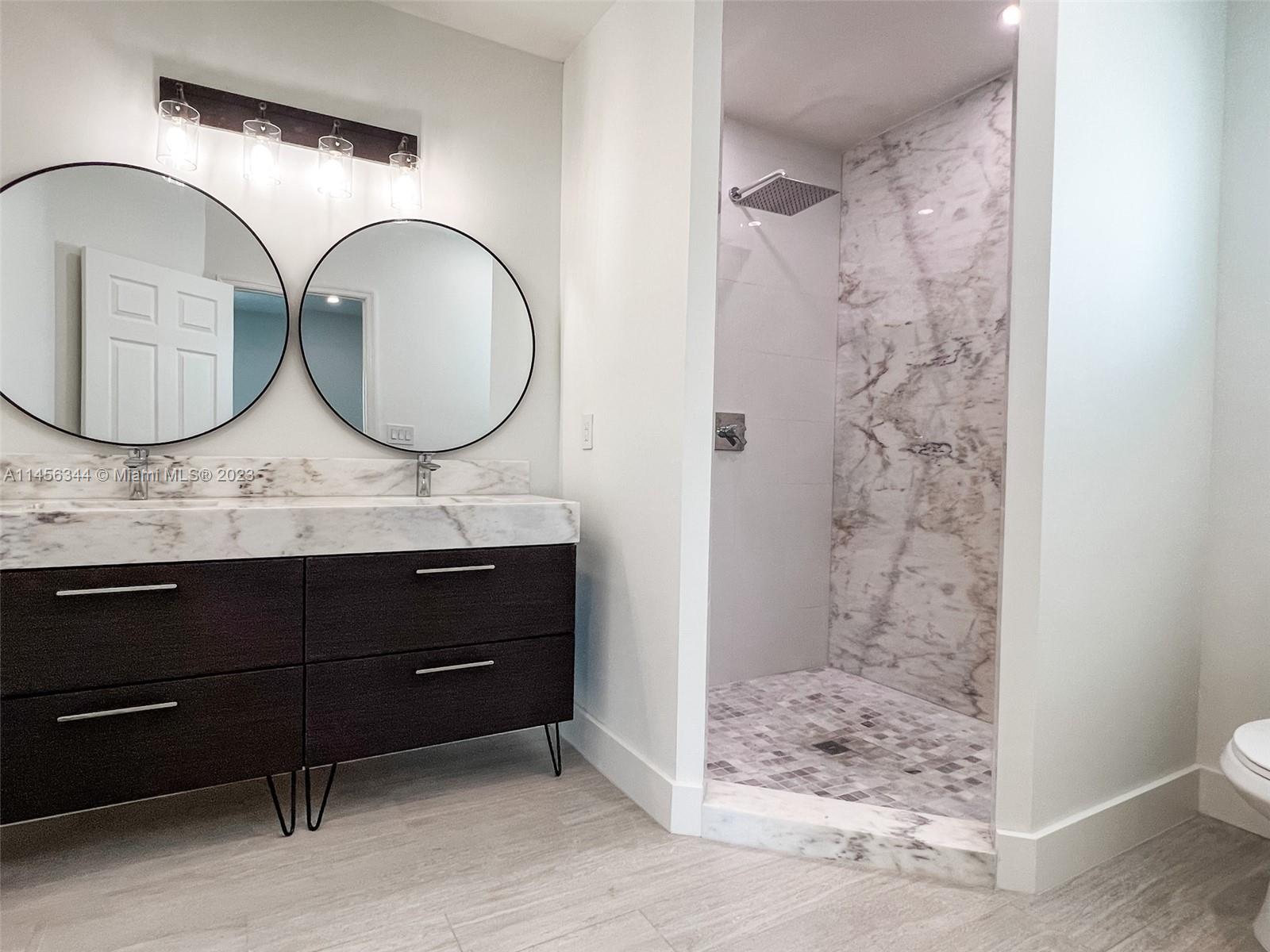 Collier City Pompano Beach, FL 33069 - Photo 10 of 28 a bathroom with a granite countertop sink a mirror and shower