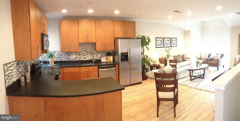 a kitchen with stainless steel appliances granite countertop a stove a refrigerator and a dining table