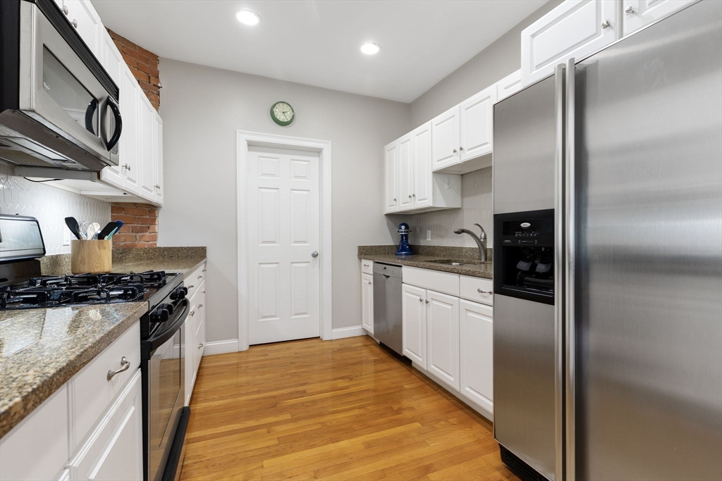 51 Dimick Street, Unit 5 Somerville, MA 02143 - Photo 13 of 28 a kitchen with stainless steel appliances granite countertop a stove a refrigerator and a refrigerator