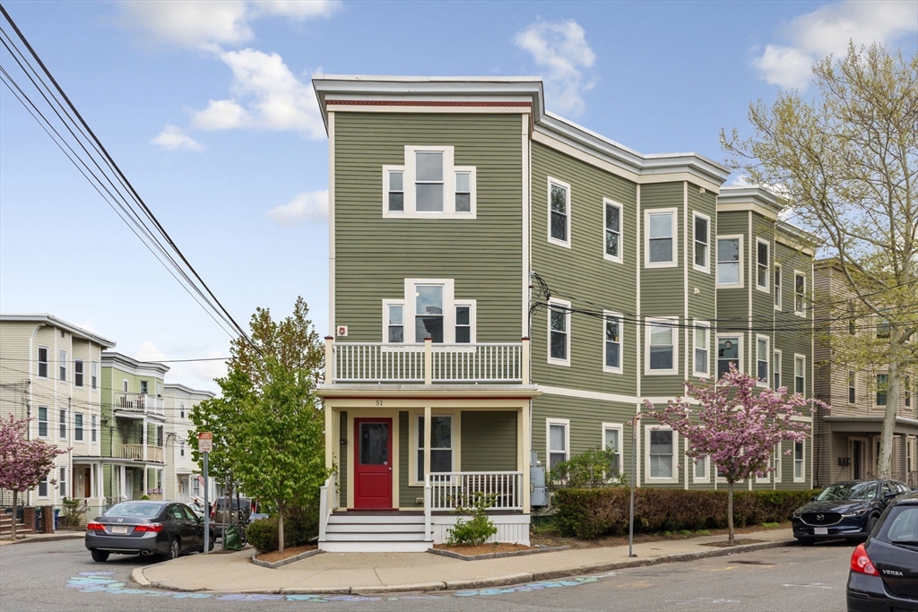 51 Dimick Street, Unit 5 Somerville, MA 02143 - Photo 27 of 28 a front view of a residential apartment building with a yard