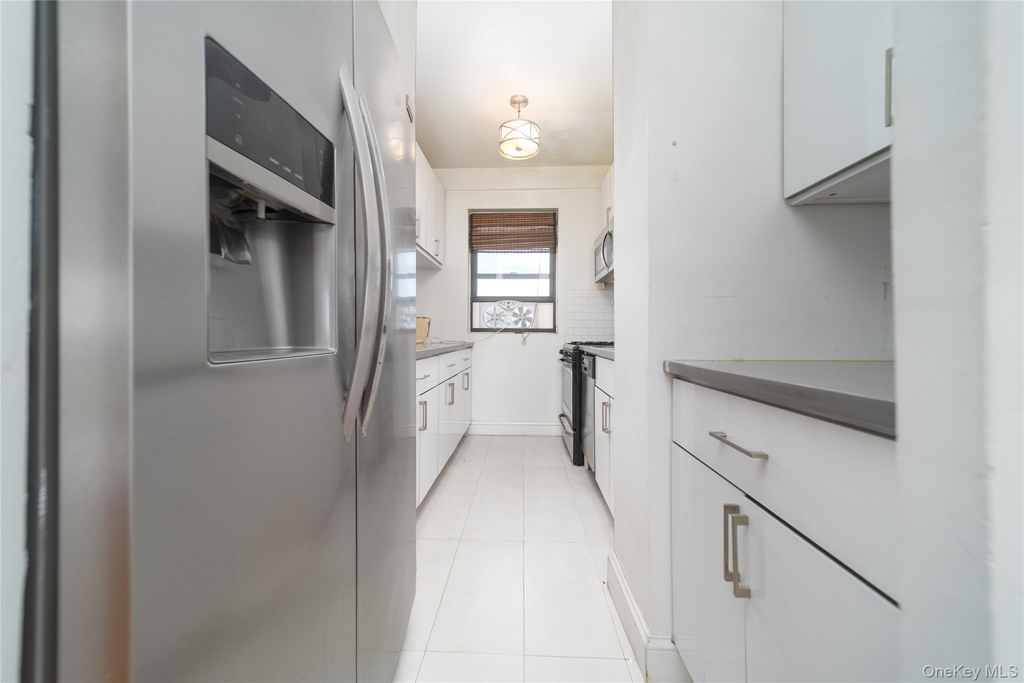99-32 66th Road, Unit 9N Queens, NY 11374 - Photo 9 of 16 a hallway with white cabinets and wooden floor