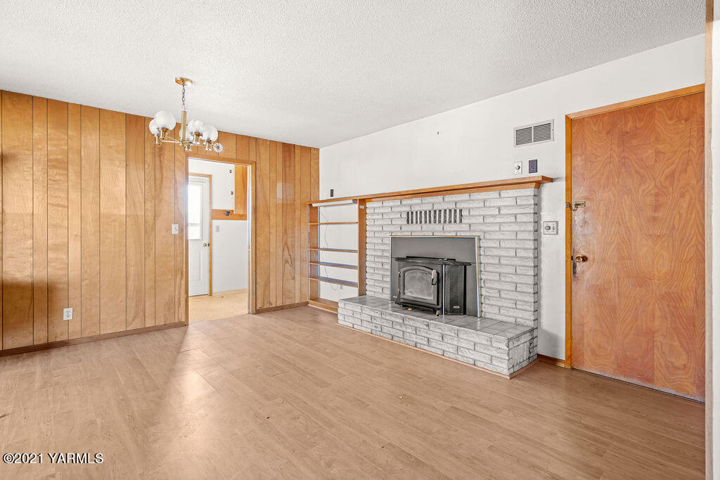 7411 Bell Road Moxee, WA 98936 - Photo 13 of 21 an empty room with wooden floor fireplace and windows
