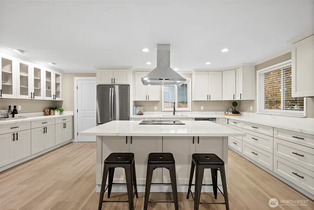 a kitchen with a dining table chairs refrigerator and cabinets