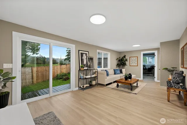 a living room with furniture floor to ceiling window and wooden floor