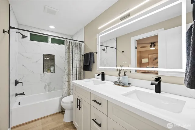 a bathroom with a double vanity sink toilet tub and shower