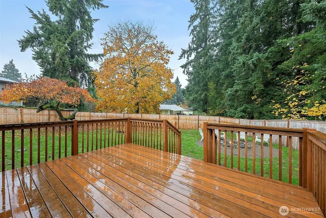 a balcony with wooden floor and trees in the back