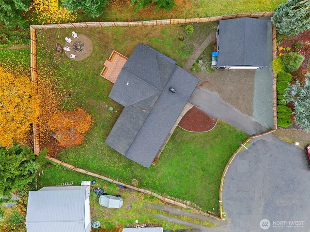 an aerial view of a house with a yard and a large tree