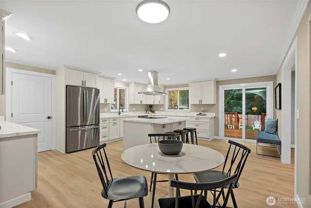 a kitchen with refrigerator and chairs