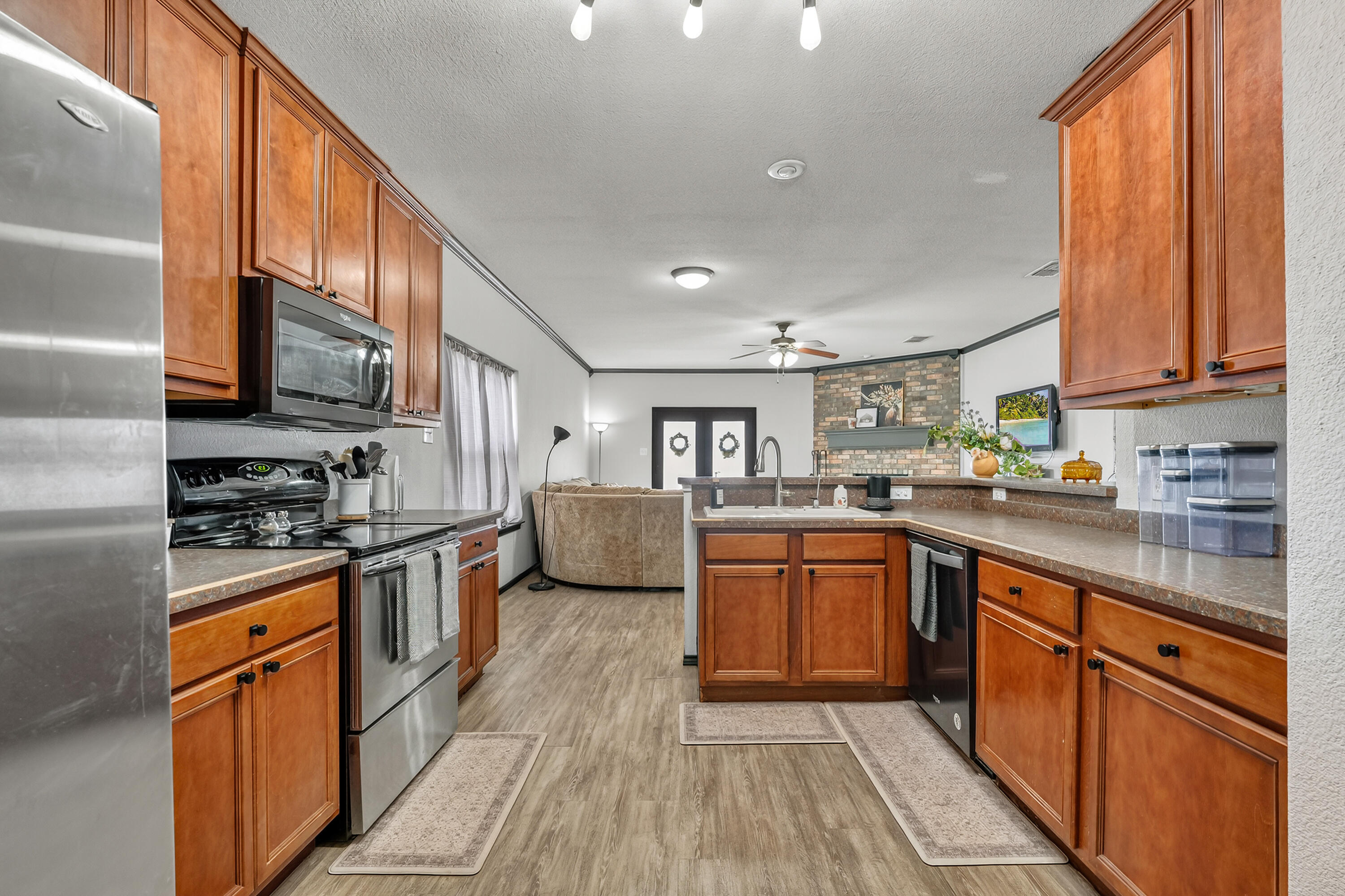 2602 112th Street Lubbock, TX 79423 - Photo 11 of 19 a kitchen with stainless steel appliances granite countertop a stove top oven a sink dishwasher a dining table and chairs with wooden floor