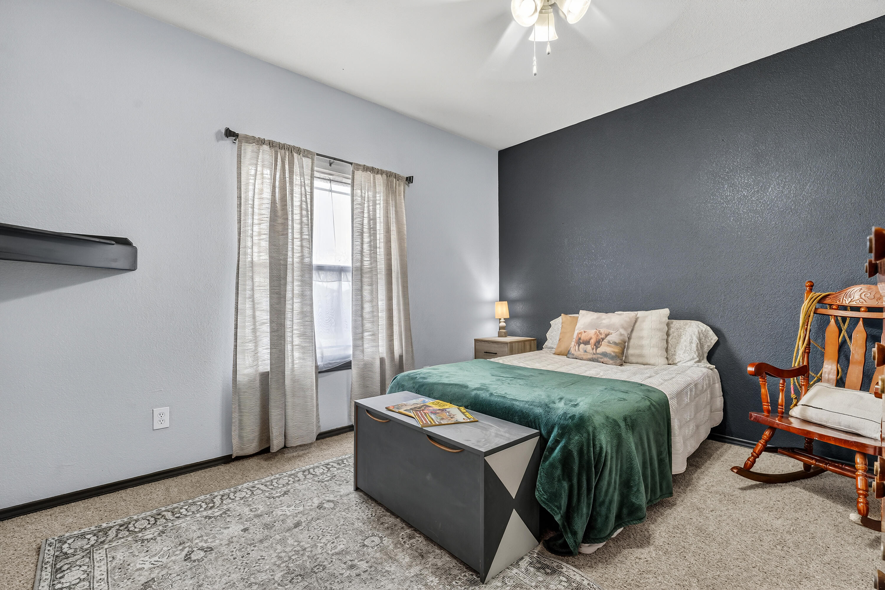 2602 112th Street Lubbock, TX 79423 - Photo 12 of 19 a bedroom with a bed and a chandelier