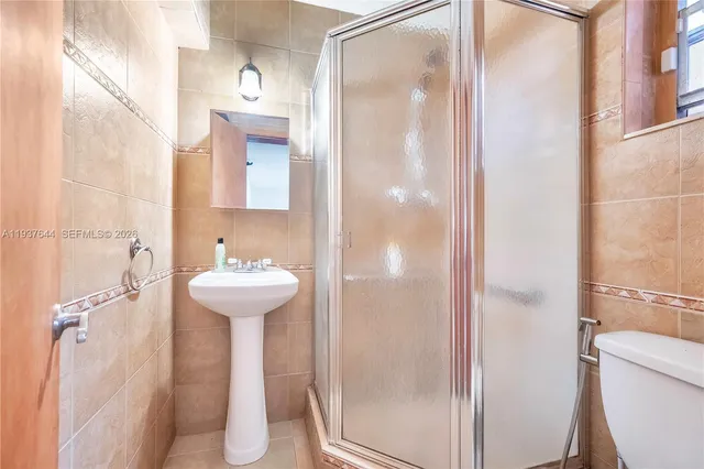 a bathroom with a sink a toilet and shower curtain