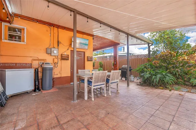 a backyard of a house with barbeque oven table and chairs