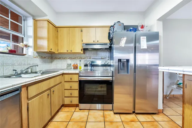 a kitchen with stainless steel appliances granite countertop a refrigerator and a sink