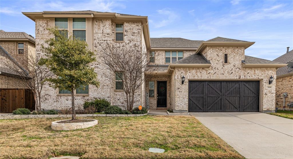 View of front of home with a garage and a front yard