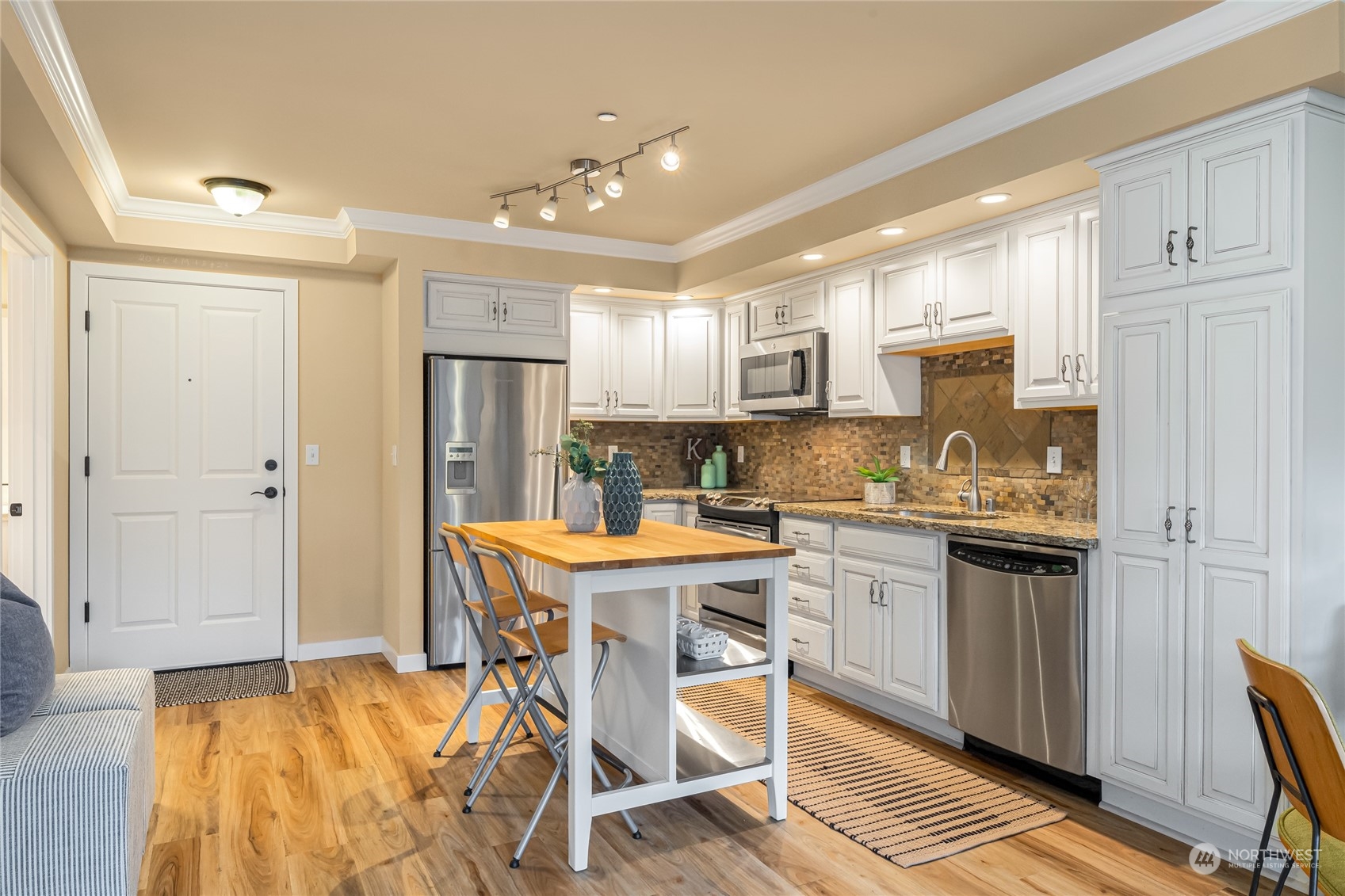 4116 California Avenue Southwest, Unit 313 Seattle, WA 98116 - Photo 7 of 18 a kitchen with kitchen island granite countertop a sink cabinets and refrigerator