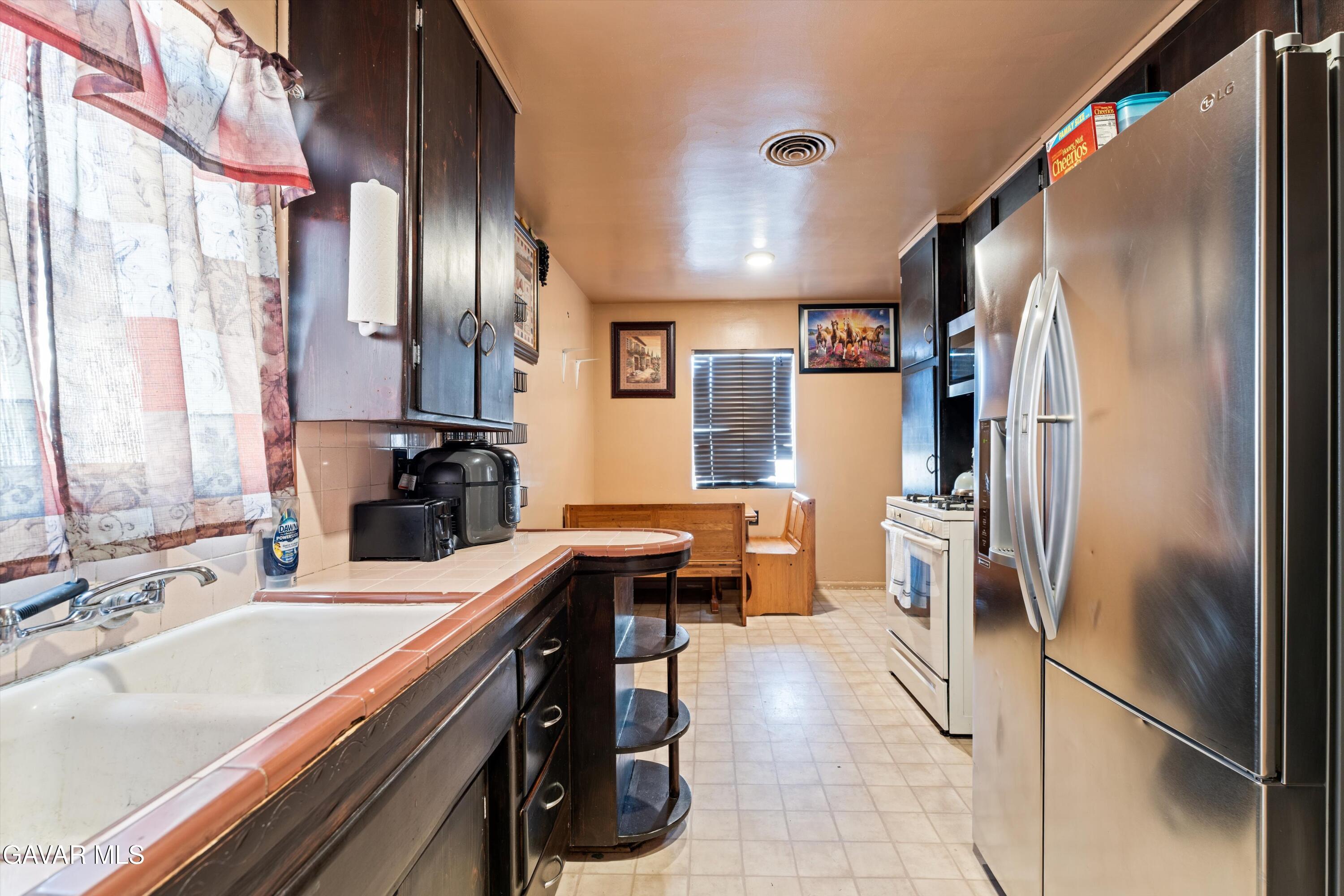 817 Oakwood Street Tehachapi, CA 93561 - Photo 3 of 12 a kitchen with stainless steel appliances granite countertop a refrigerator and a sink