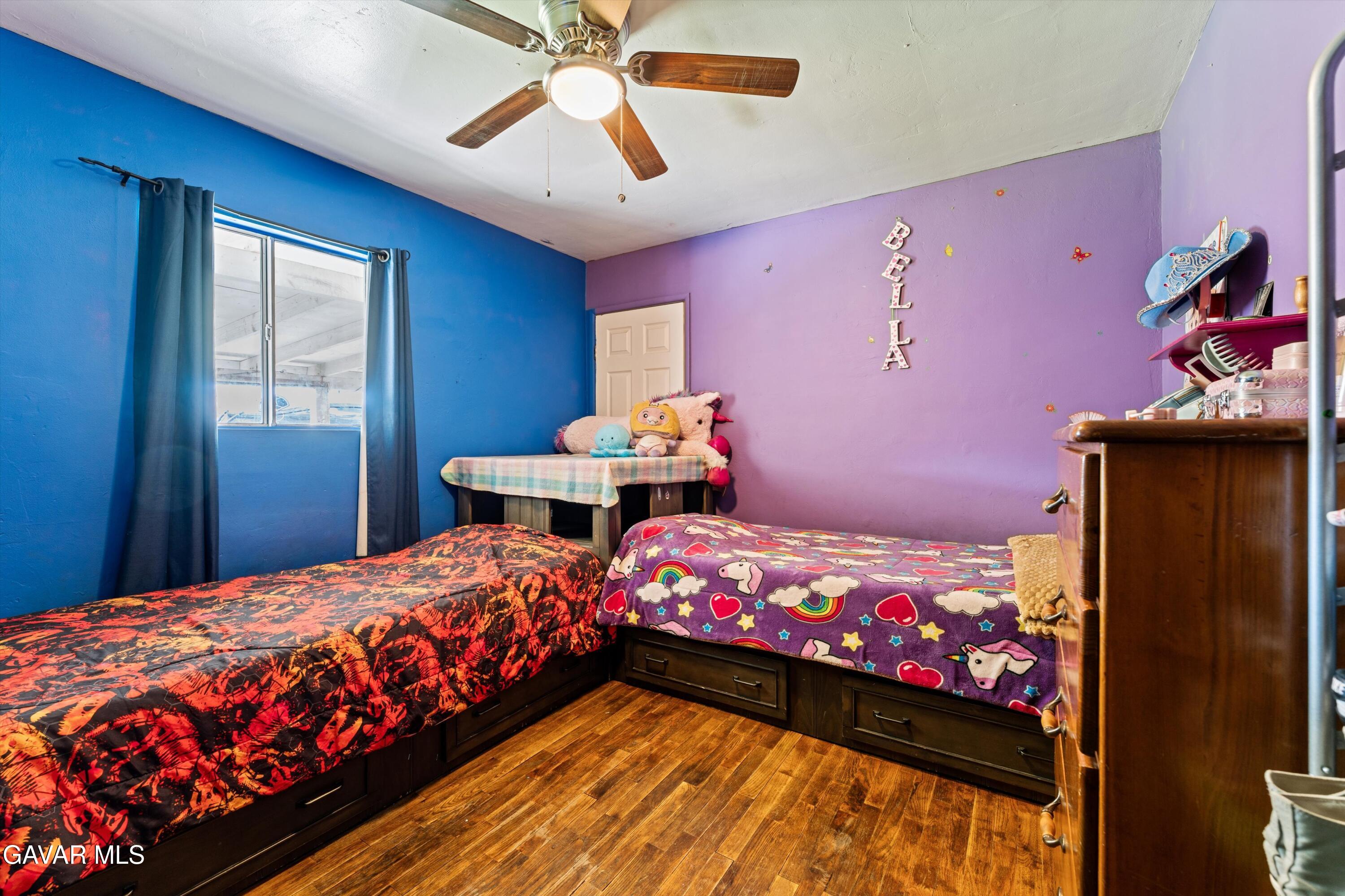 817 Oakwood Street Tehachapi, CA 93561 - Photo 6 of 12 a bedroom with a bed and a chandelier