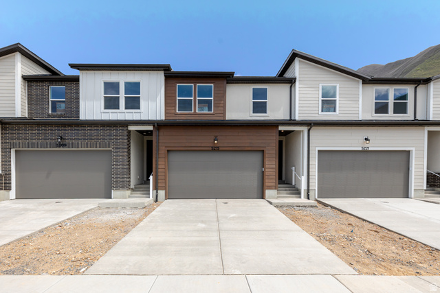 5215 South Acacia Drive, Unit 703 Mapleton, UT 84664 - Photo 1 of 1 View of front of property with an attached garage, concrete driveway, and board and batten siding