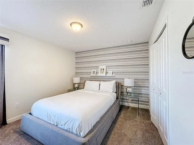 a bedroom with a bed and flat screen tv