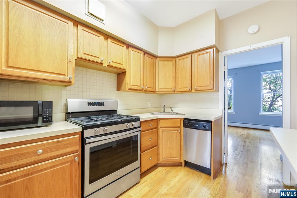 523 Adams Street, Unit 3 Hoboken, NJ 07030 - Photo 11 of 19 a kitchen with stainless steel appliances granite countertop a stove a sink and a microwave