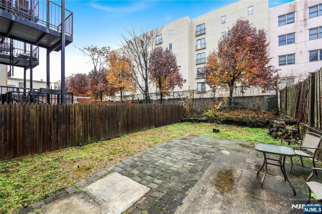 523 Adams Street, Unit 3 Hoboken, NJ 07030 - Photo 19 of 19 a backyard of a house with barbeque oven table and chairs