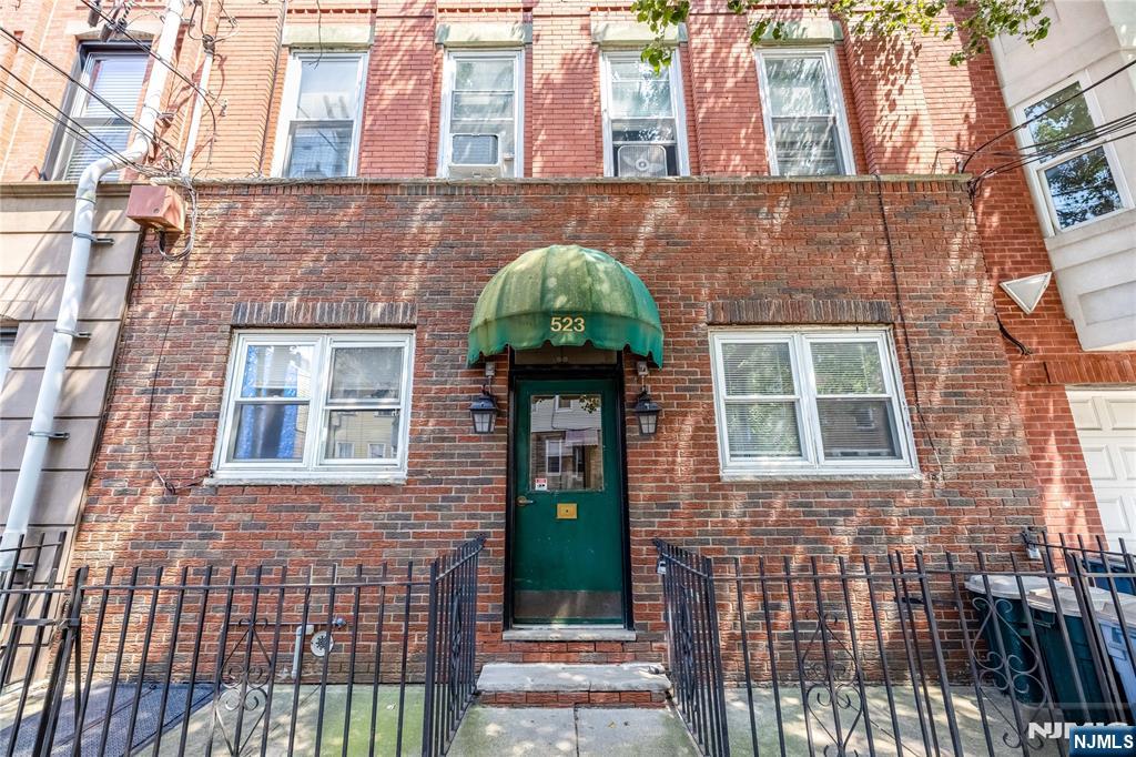 523 Adams Street, Unit 3 Hoboken, NJ 07030 - Photo 2 of 19 front view of a brick house with a small yard