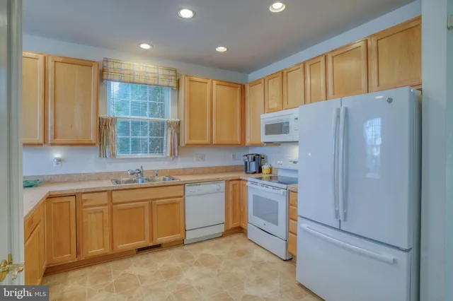 a kitchen with stainless steel appliances granite countertop a refrigerator sink and cabinets