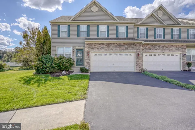 a front view of a house with a garden and plants