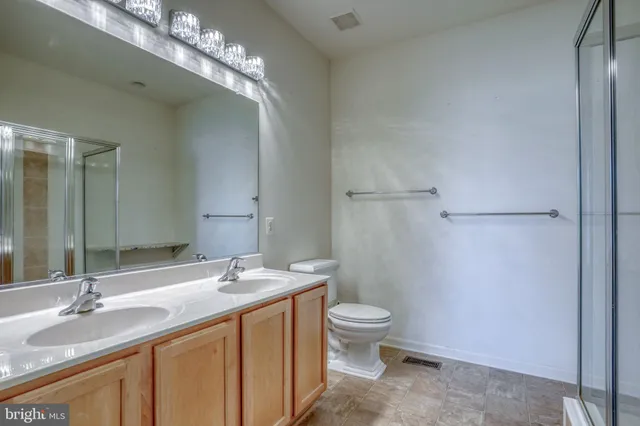 a bathroom with a granite countertop sink a toilet and a mirror
