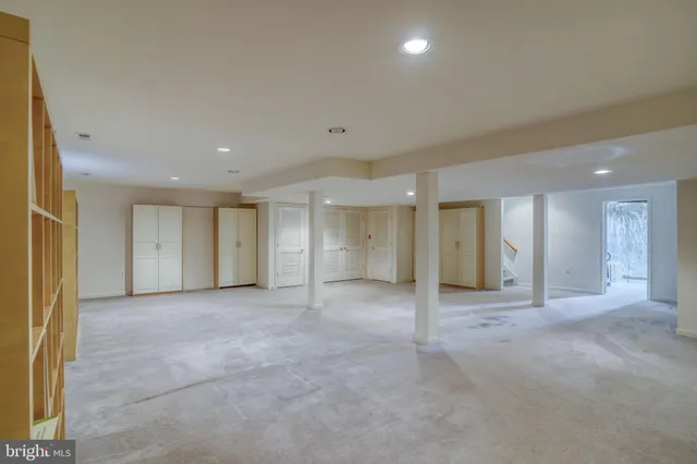 an empty room with windows and cabinet