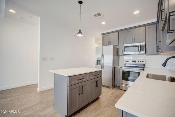 a kitchen with a sink a counter space appliances and cabinets