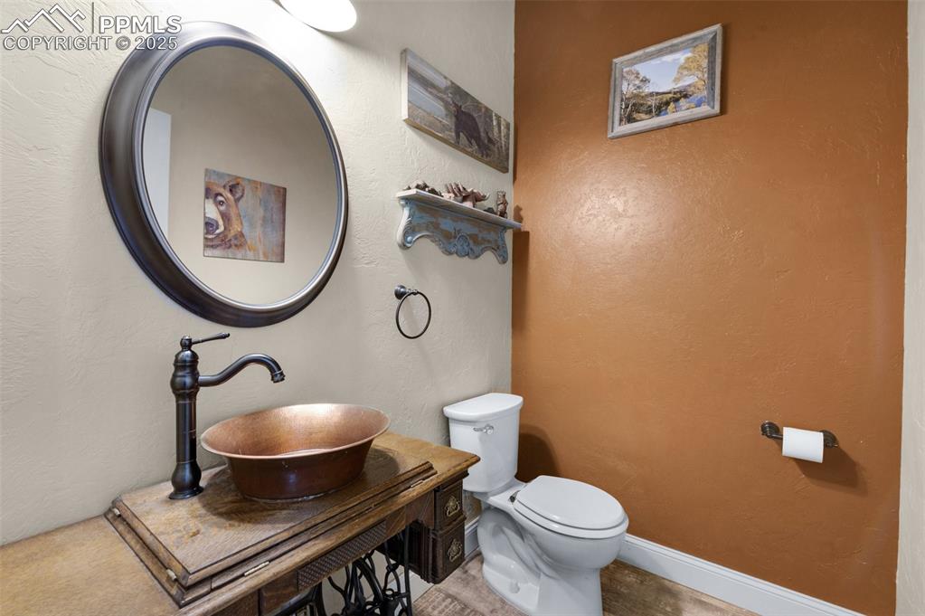 311 Knickerbocker Road Silver Cliff, CO 81252 - Photo 22 of 50 a bathroom with a toilet a sink and mirror