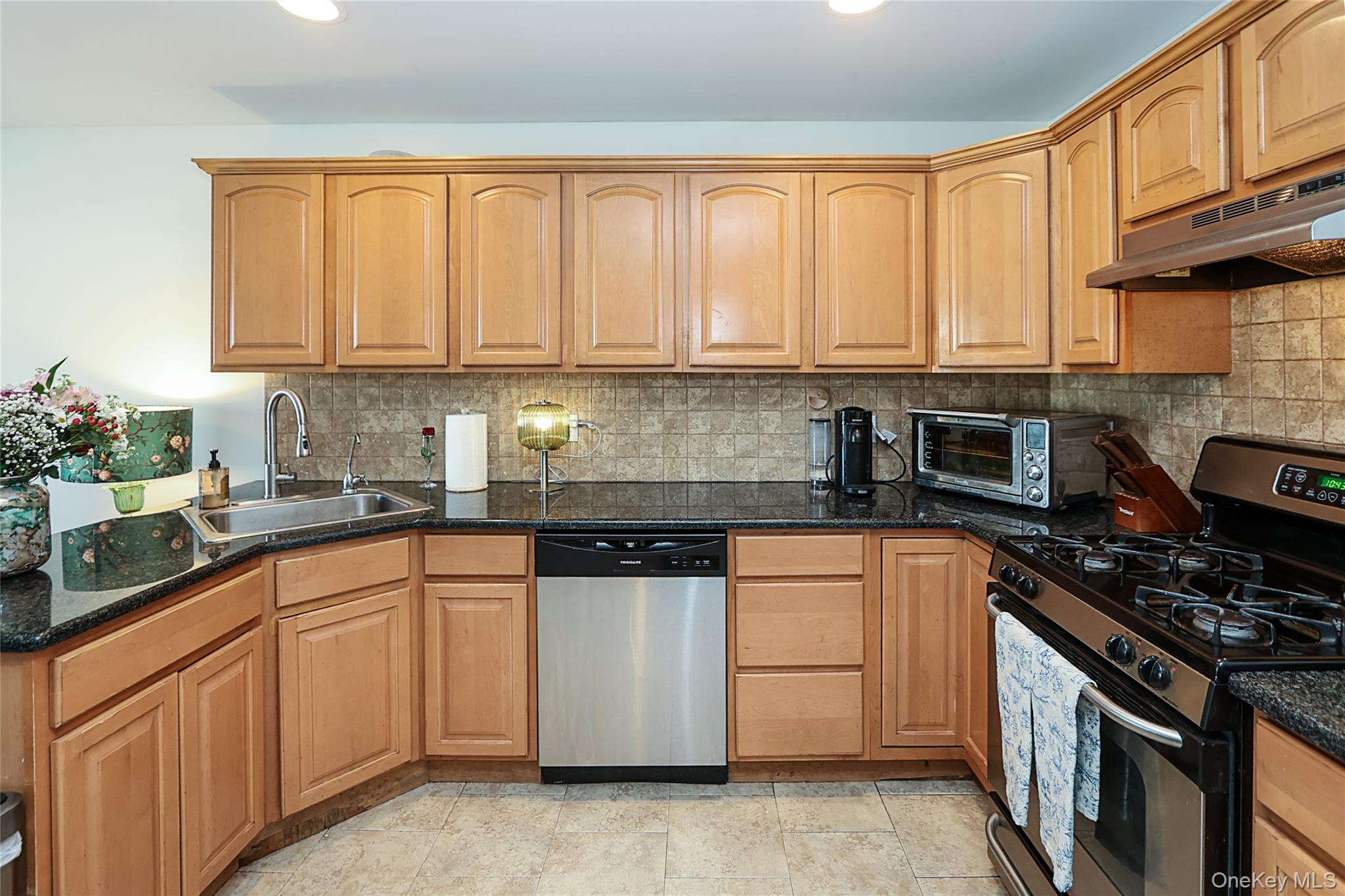 54 Landing Road Glen Cove, NY 11542 - Photo 12 of 24 a kitchen with stainless steel appliances granite countertop a stove a sink and white cabinets