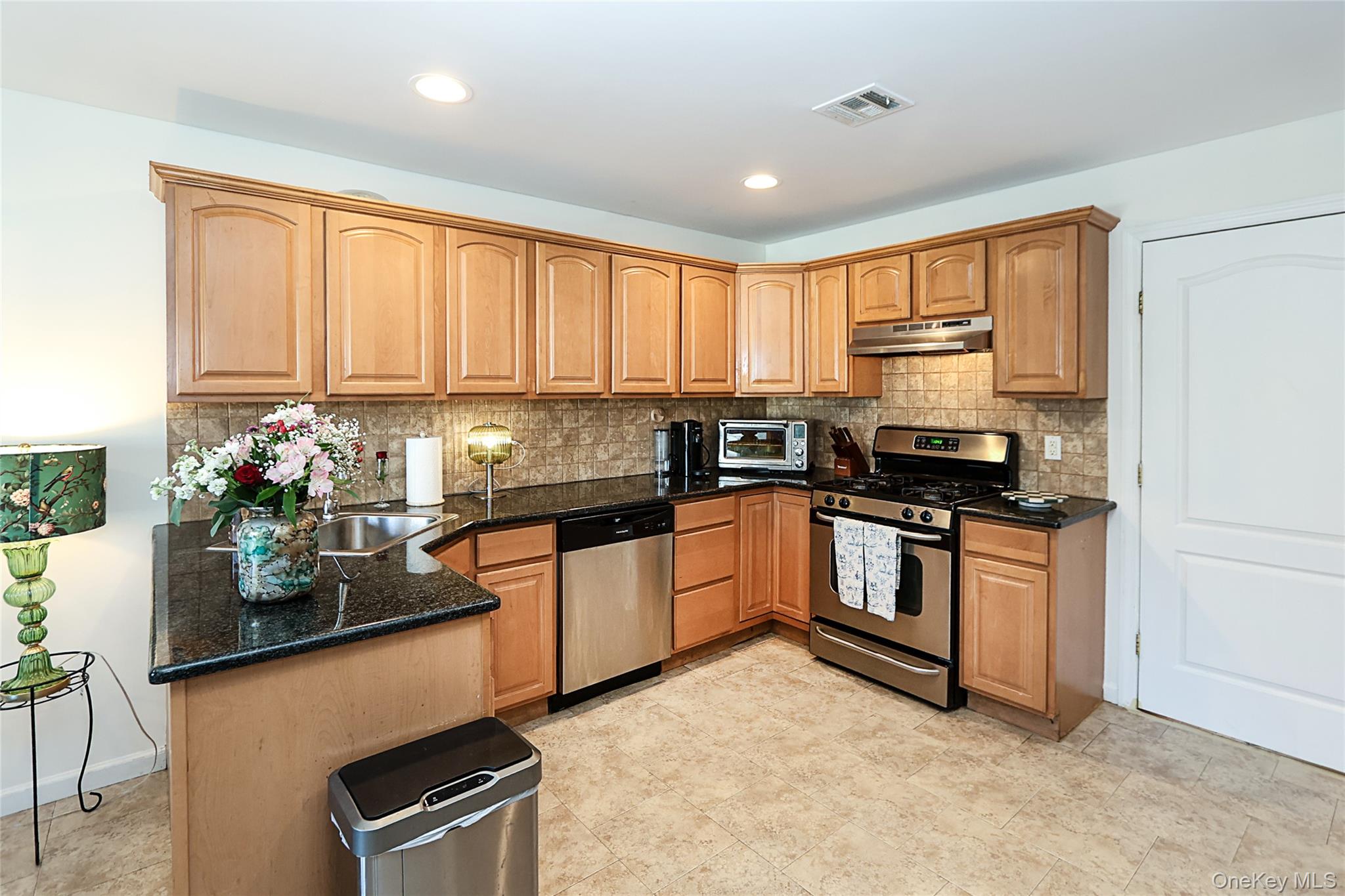 54 Landing Road Glen Cove, NY 11542 - Photo 13 of 24 a kitchen with stainless steel appliances granite countertop a stove a sink and a refrigerator