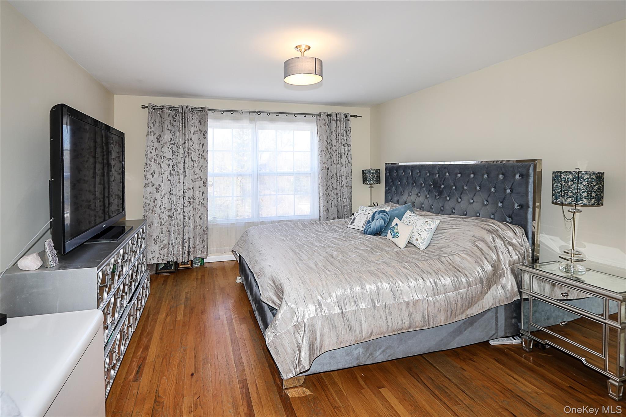 54 Landing Road Glen Cove, NY 11542 - Photo 18 of 24 a bedroom with a bed and a flat tv screen on a dresser