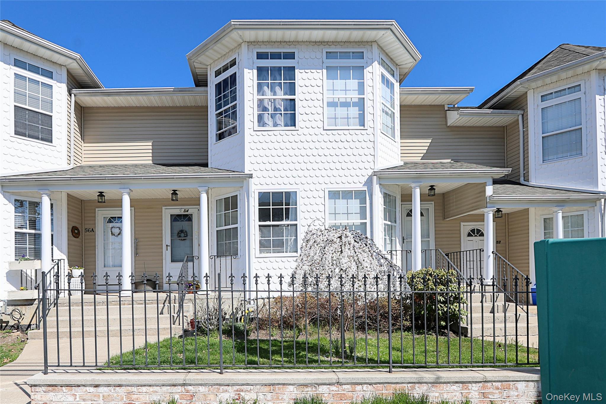 54 Landing Road Glen Cove, NY 11542 - Photo 3 of 24 a front view of a house with a garden and plants