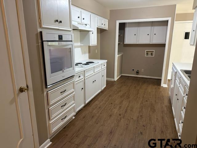 5702 Foxcroft Road Tyler, TX 75703 - Photo 4 of 10 a kitchen with white cabinets and white appliances