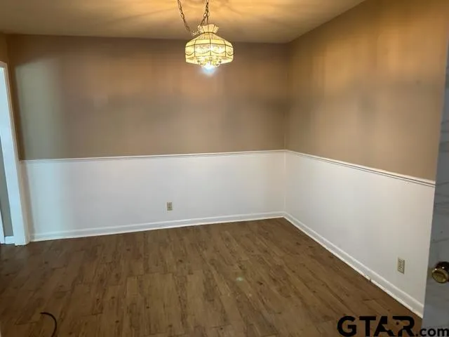 en empty room with wooden floor and window