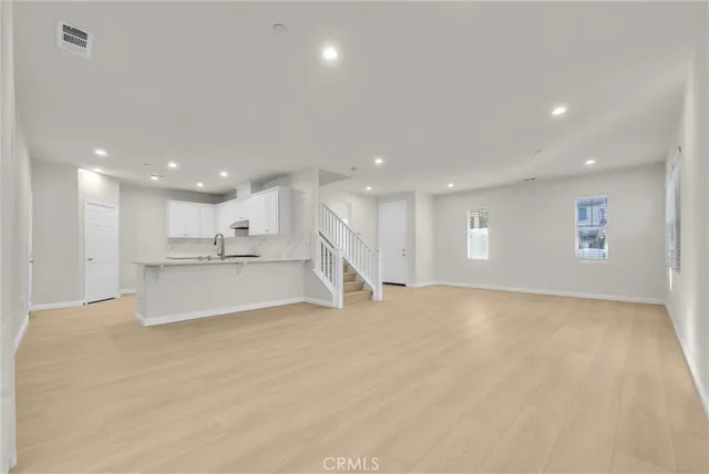 a view of an empty room with a kitchen
