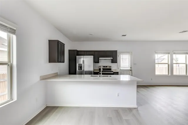 a kitchen with a stove top oven and refrigerator